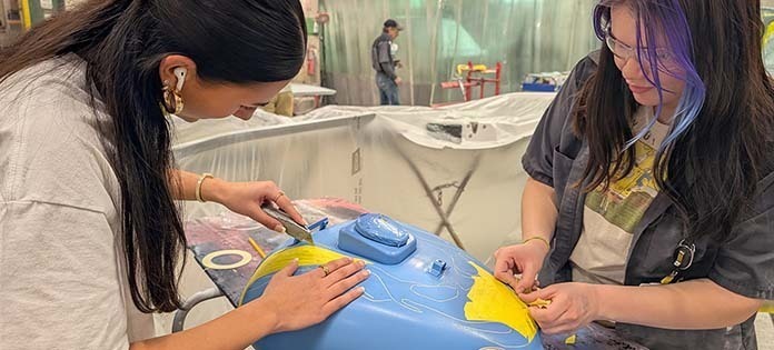 Image of Collision Repair students working on motorcycle gas tank.